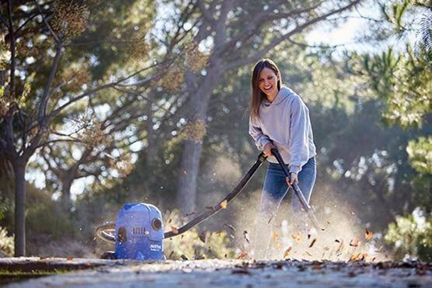 Woman blowing leaves with Wet and Dry vacuum cleaner
