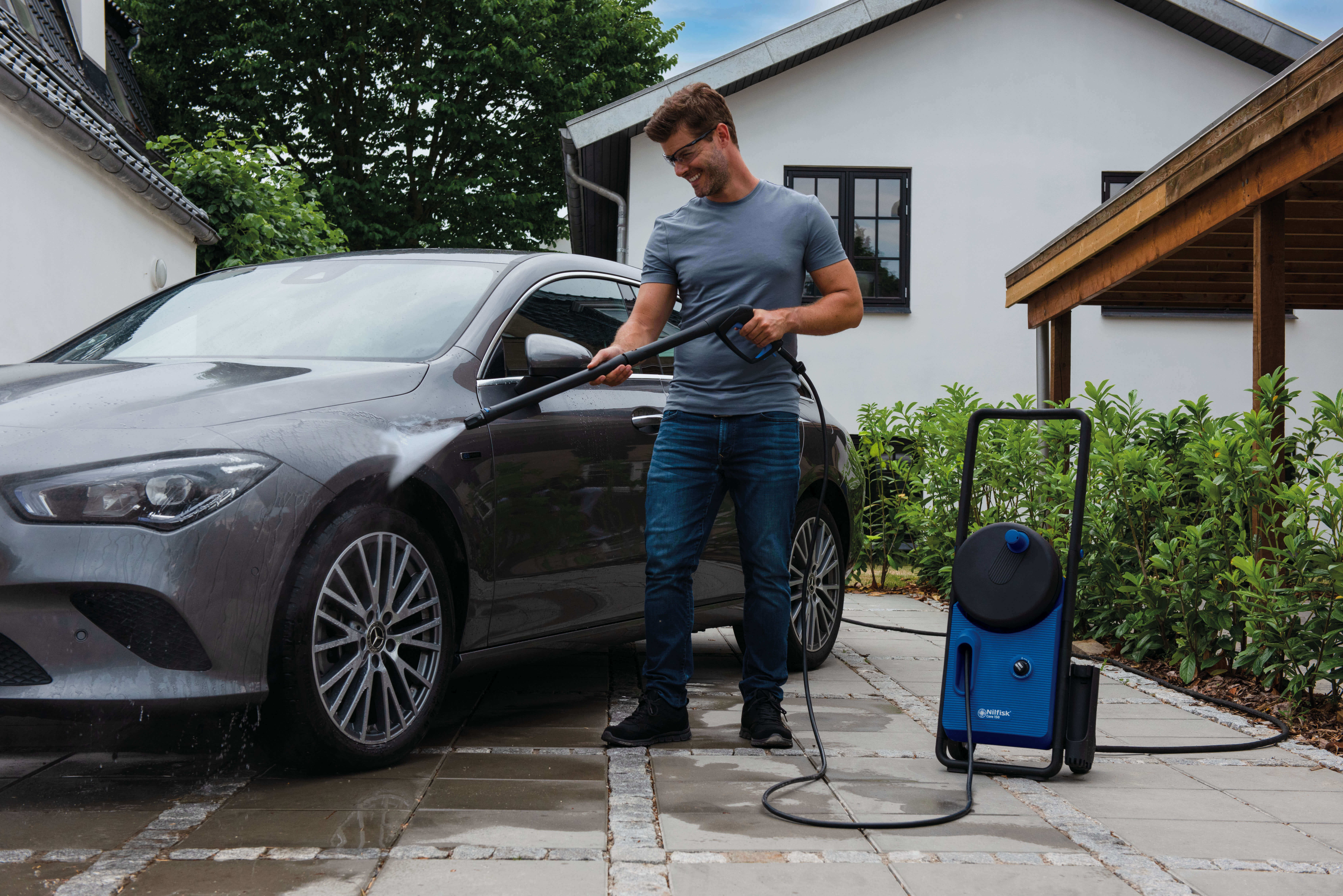 Man cleaning car with high pressure washer